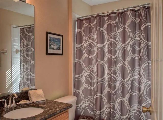 a bathroom with a shower curtain and a sink