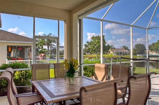 a view of a patio with table and chairs potted plants with wooden floor and floor to ceiling window