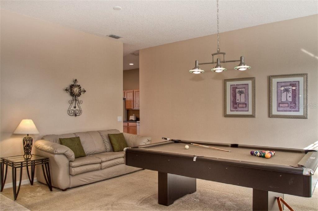 4418 Useppa Drive Bradenton, FL 34203 - Photo 2 of 22 a living room with a couch and chandelier