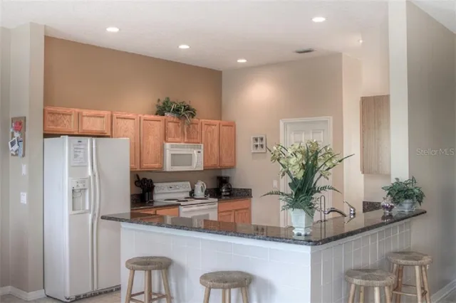 a kitchen with white cabinets and a refrigerator
