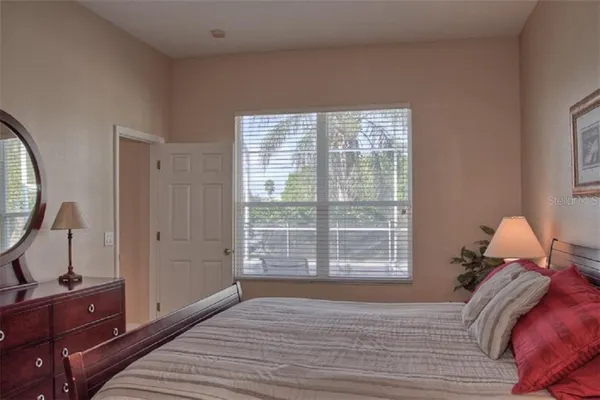 a view of a bedroom with a bed and wooden floor