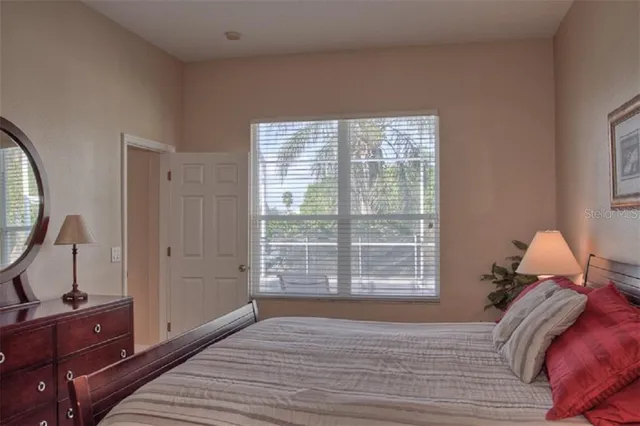a view of a bedroom with a bed and wooden floor