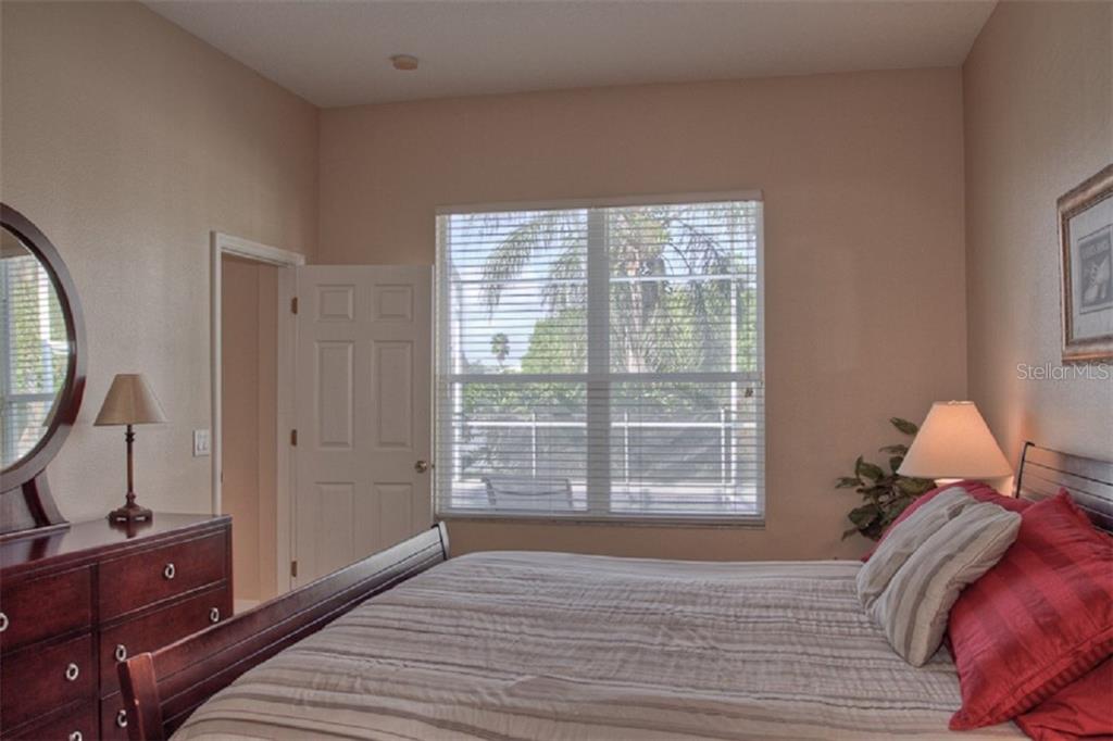 4418 Useppa Drive Bradenton, FL 34203 - Photo 9 of 22 a view of a bedroom with a bed and wooden floor
