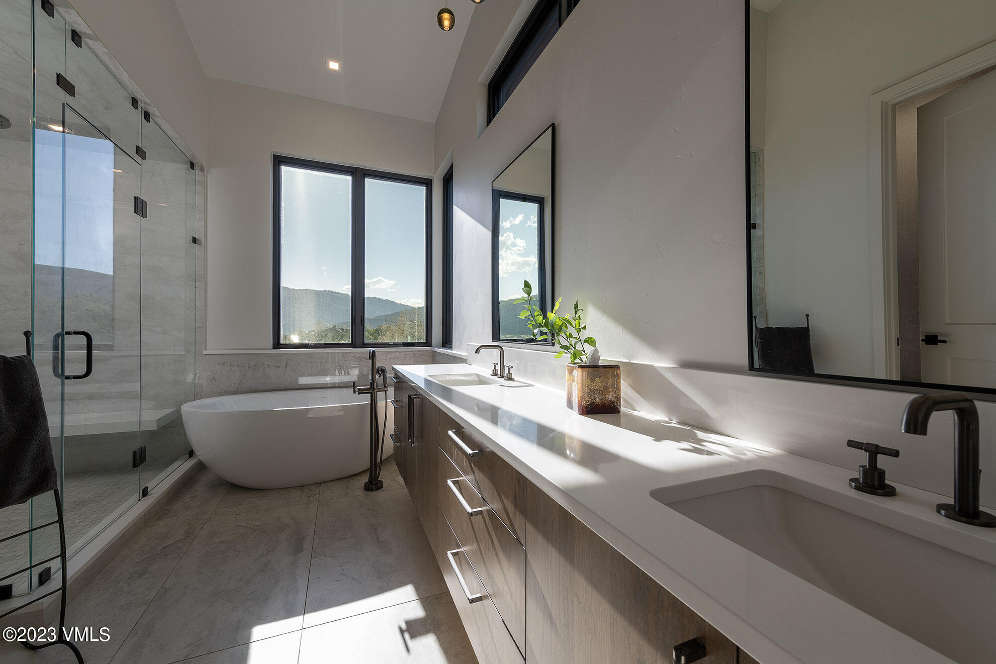 118 Juniper Ridge Road Edwards, CO 81632 - Photo 5 of 16 a bathroom with a double vanity sink a large mirror and a bathtub