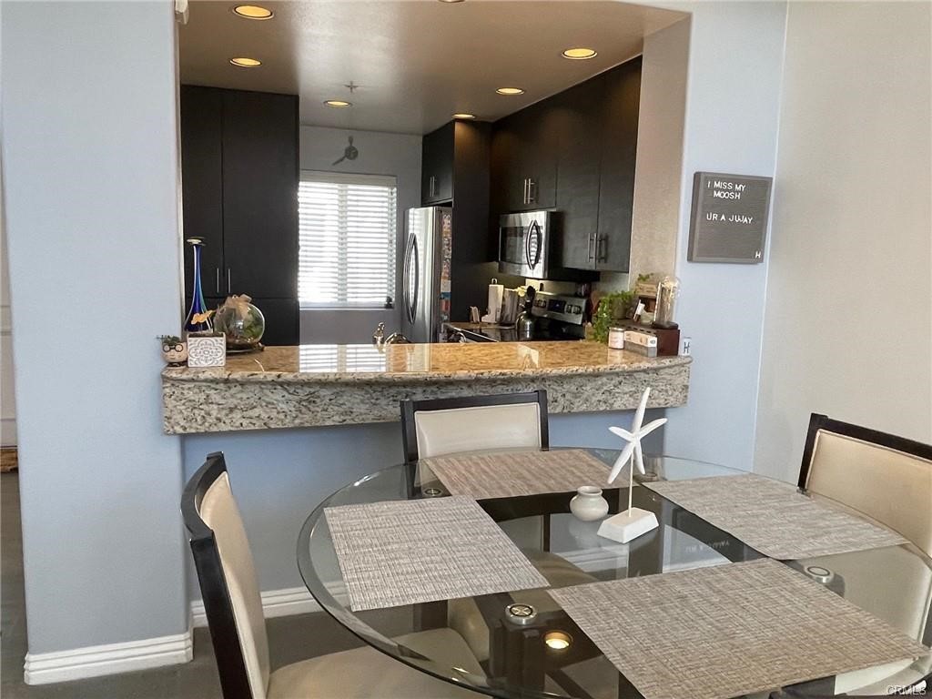 2233 Martin, Unit 413 Irvine, CA 92612 - Photo 22 of 45 a dining room with kitchen island a table and chairs