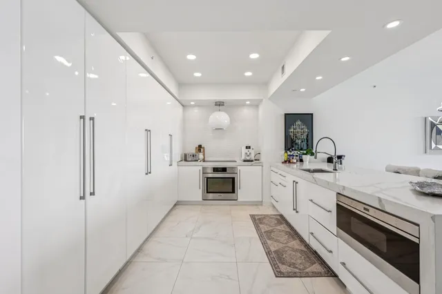 a kitchen with white cabinets and stainless steel appliances