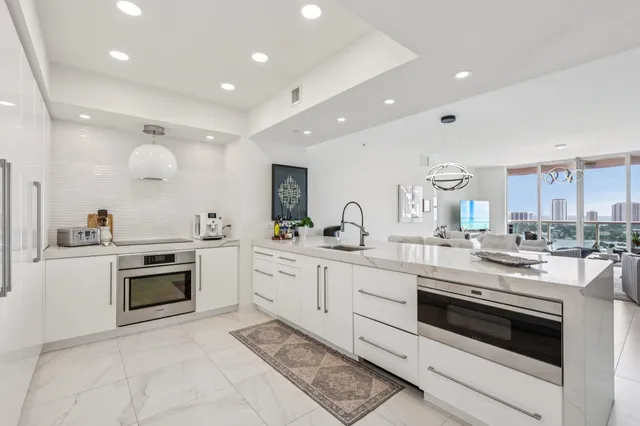 a kitchen with white cabinets and sink