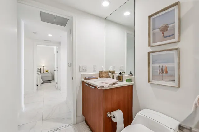 a bathroom with a granite countertop sink toilet and shower