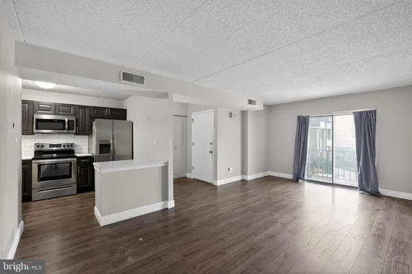 a view of a kitchen with a sink stove cabinets and empty room
