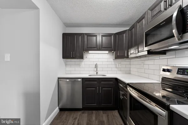 a kitchen with stainless steel appliances a sink stove and microwave