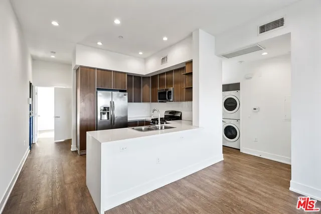 a kitchen with stainless steel appliances a refrigerator and a stove top oven