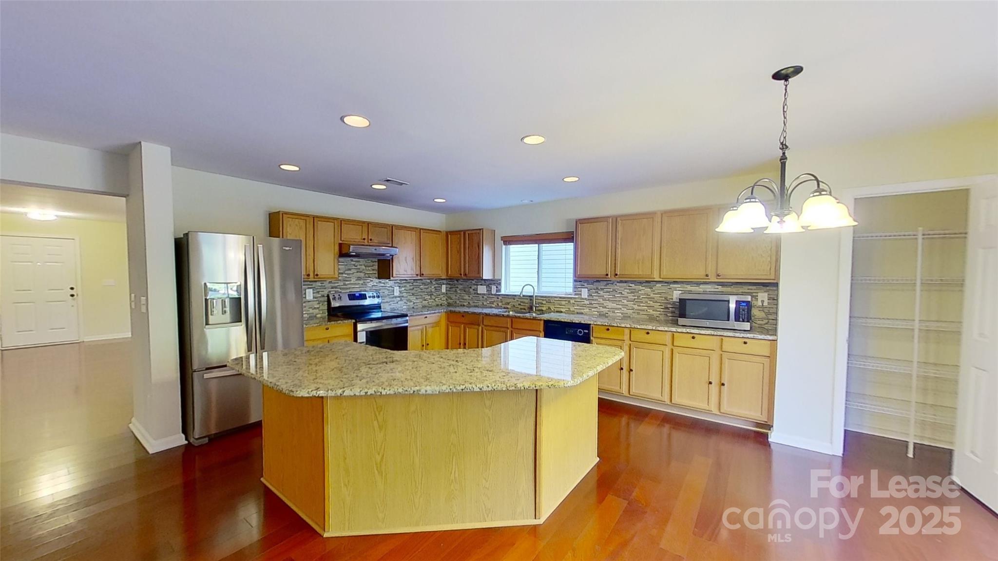 9029 Seamill Road Charlotte, NC 28278 - Photo 3 of 15 a view of a kitchen with kitchen island a counter top space appliances and a ceiling fan