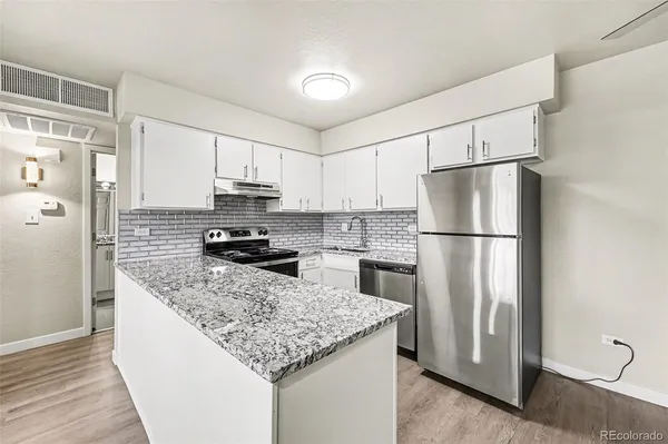 a kitchen with a refrigerator a stove top oven and a refrigerator