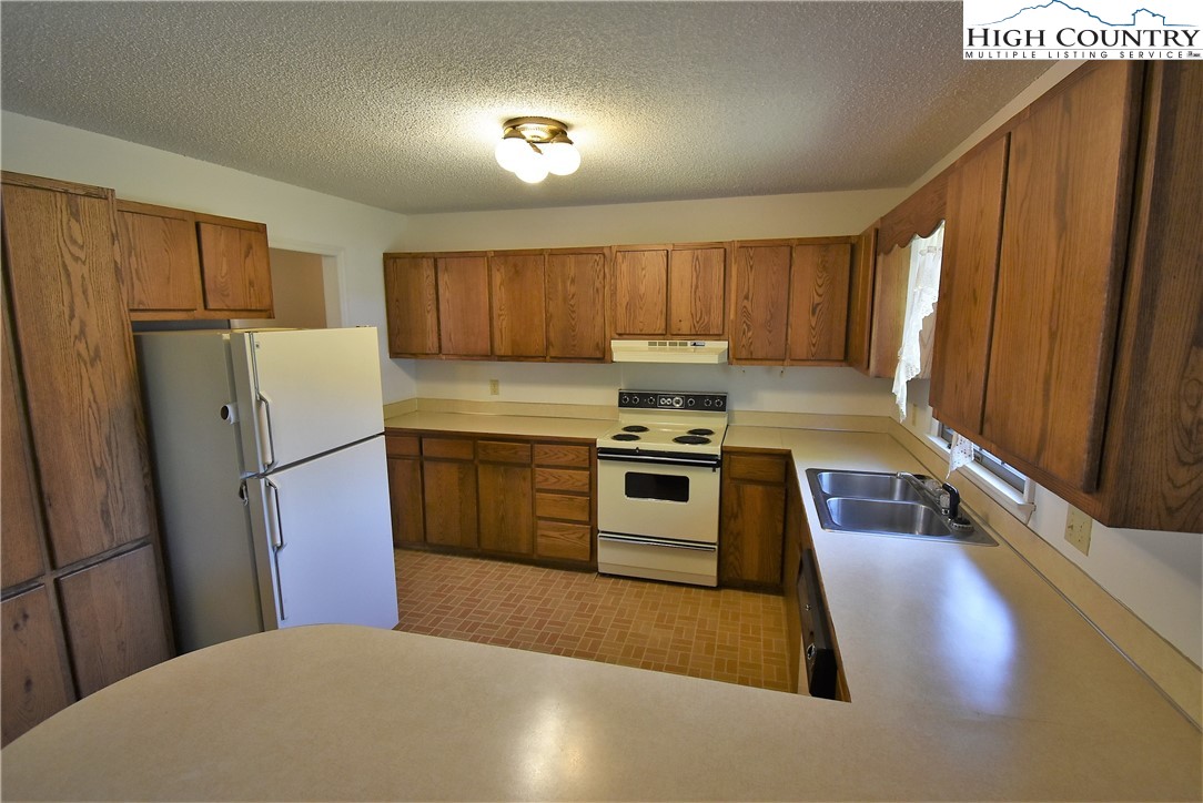 114 Dolinger Road Whitetop, VA 24292 - Photo 11 of 28 a kitchen with sink a refrigerator and a stove