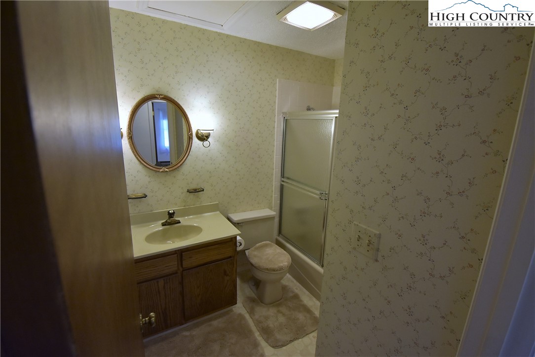 114 Dolinger Road Whitetop, VA 24292 - Photo 20 of 28 a bathroom with a granite countertop toilet a sink and mirror