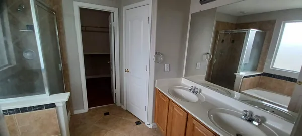 a bathroom with a double vanity sink and mirror