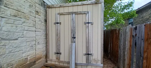 a view of a wooden door in front of house