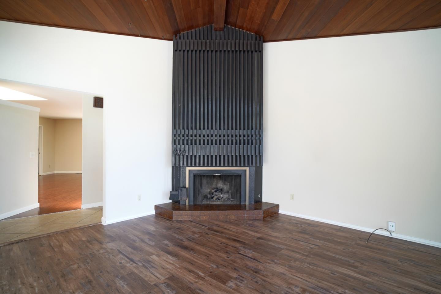 4059 Crest Road Pebble Beach, CA 93953 - Photo 11 of 27 a view of an empty room with wooden floor fireplace and a window