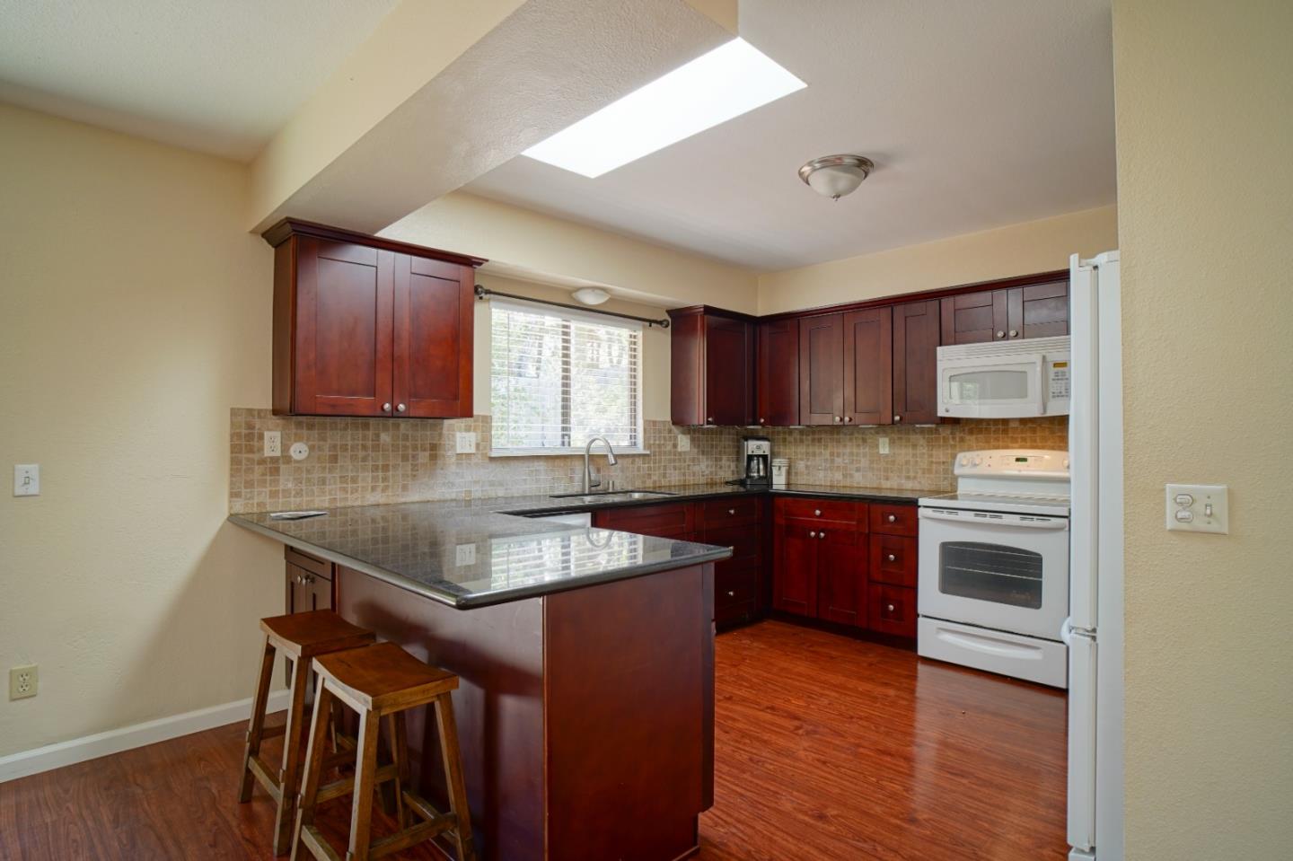4059 Crest Road Pebble Beach, CA 93953 - Photo 12 of 27 a kitchen with stainless steel appliances granite countertop a stove a sink dishwasher and a microwave oven with wooden floor