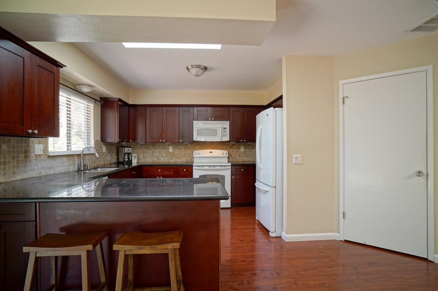 4059 Crest Road Pebble Beach, CA 93953 - Photo 13 of 27 a kitchen with kitchen island granite countertop wooden cabinets a sink and a stove