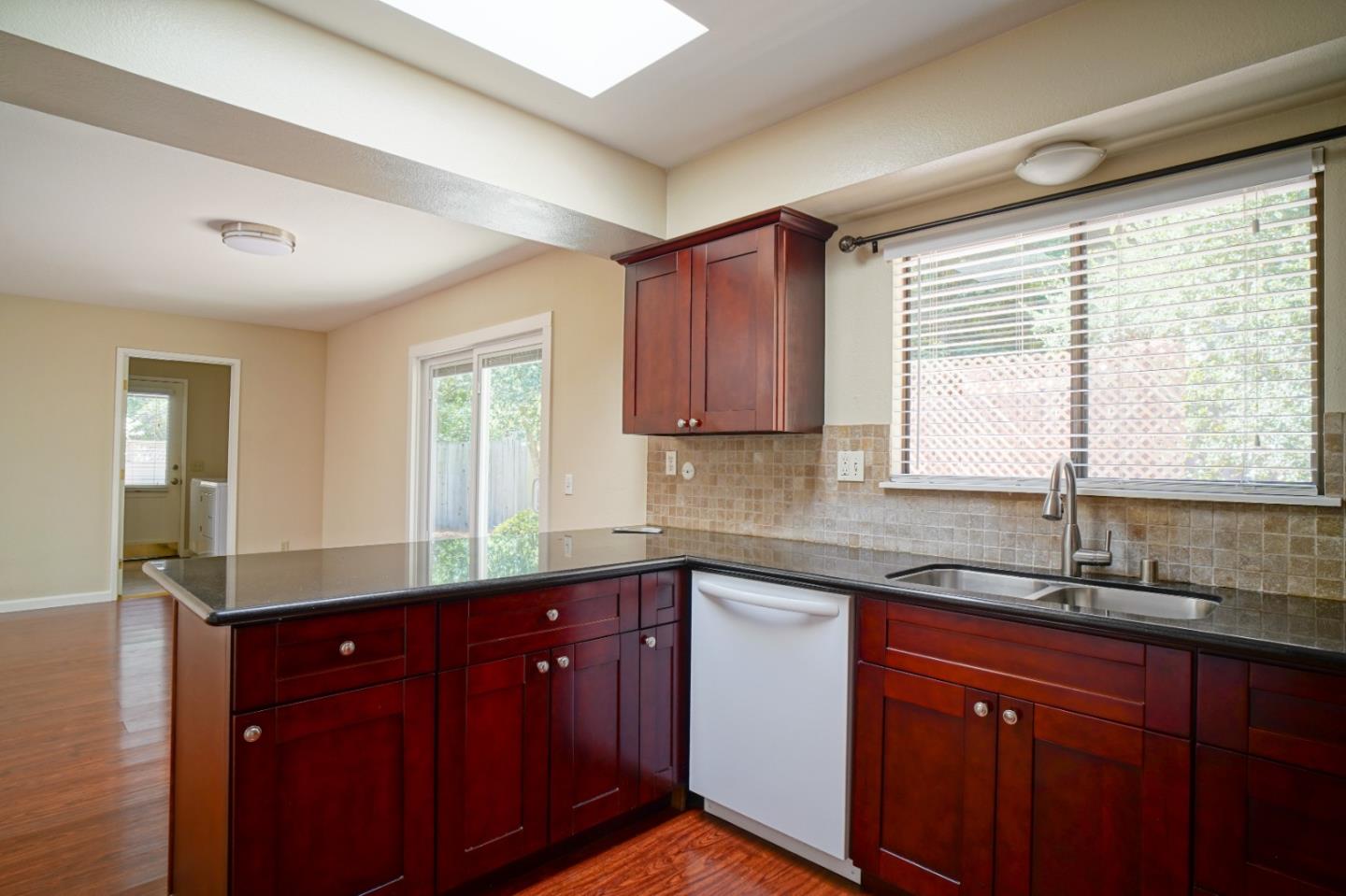 4059 Crest Road Pebble Beach, CA 93953 - Photo 16 of 27 a kitchen with granite countertop wooden cabinets sink and window