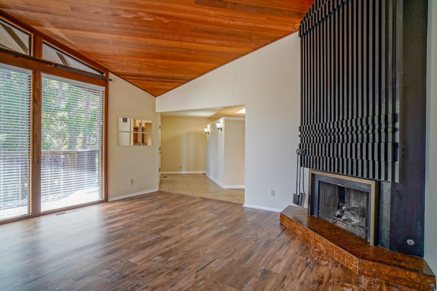 4059 Crest Road Pebble Beach, CA 93953 - Photo 10 of 27 a view of an empty room with wooden floor fireplace and a window