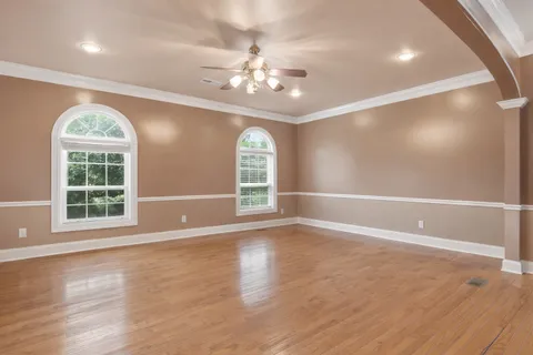 a view of empty room with wooden floor and window