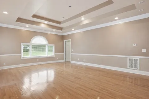 a kitchen with kitchen island granite countertop wooden cabinets a sink a stove a oven and a refrigerator