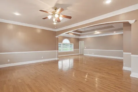 a kitchen with stainless steel appliances granite countertop a refrigerator a sink dishwasher and wooden cabinets with wooden floor