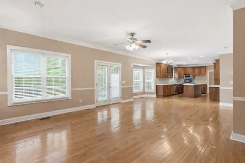 a kitchen with stainless steel appliances wooden floors wooden cabinets and sink