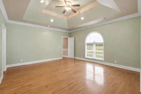 a view of an empty room with a fireplace and a chandelier fan