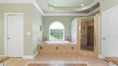 a large bathroom with a tub a sink and mirror
