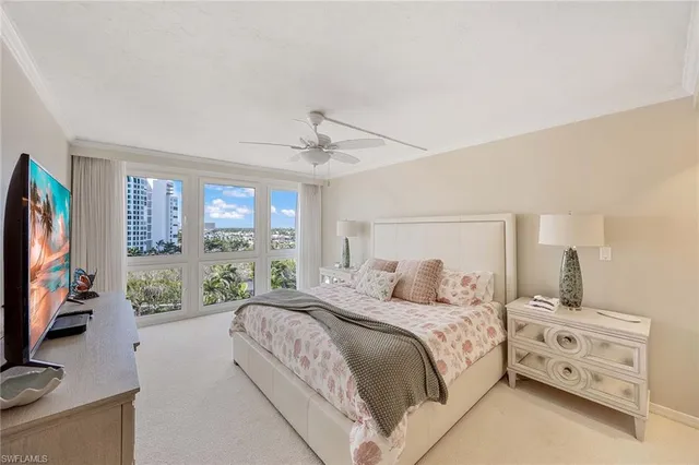 a bedroom with a bed a large window and flat screen tv