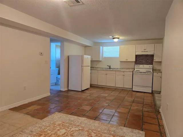 a kitchen with white cabinets and white appliances
