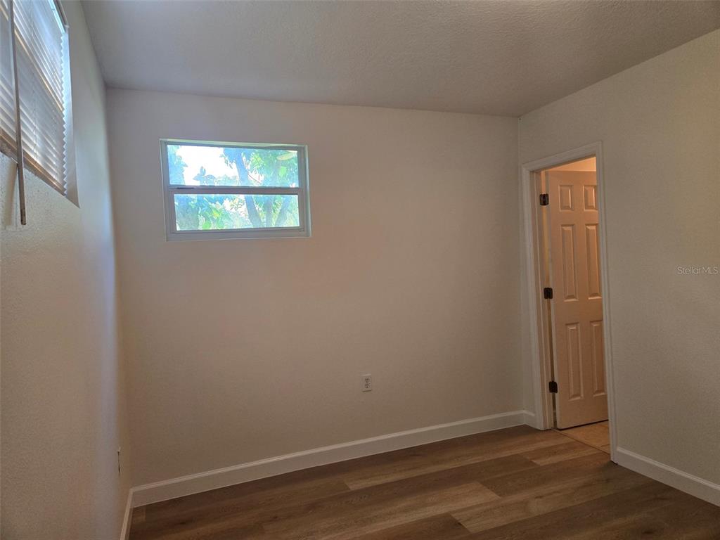 2115 5th Street, Unit 2 Sarasota, FL 34237 - Photo 11 of 22 an empty room with wooden floor and a window