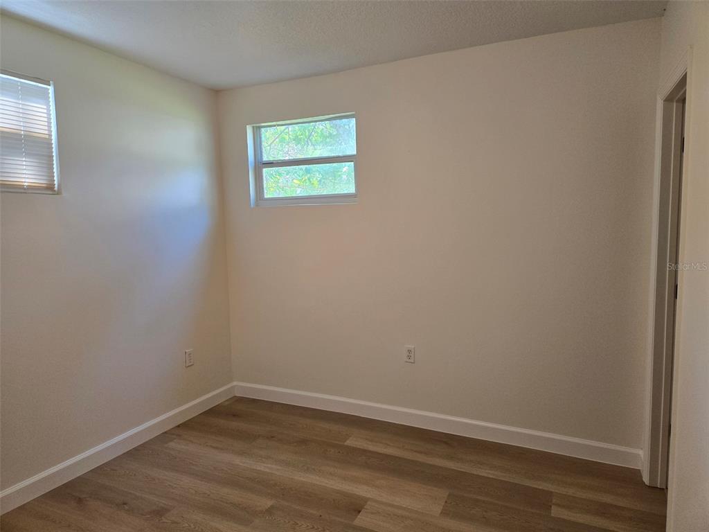 2115 5th Street, Unit 2 Sarasota, FL 34237 - Photo 14 of 22 a view of an empty room with wooden floor and a window