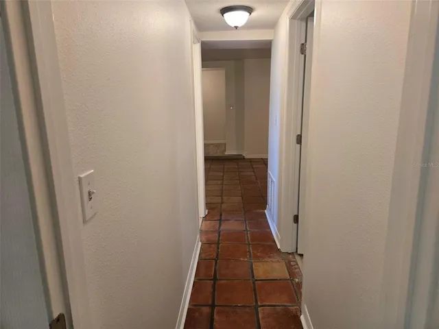 a view of an empty room and wooden floor and a window