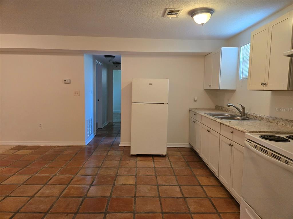 2115 5th Street, Unit 2 Sarasota, FL 34237 - Photo 6 of 22 a kitchen with a refrigerator a stove top oven and cabinets