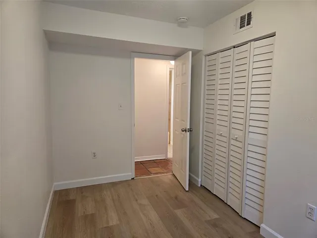 an empty room with wooden floor and closet