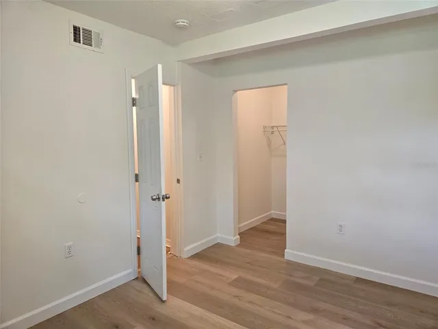 an empty room with wooden floor and a window