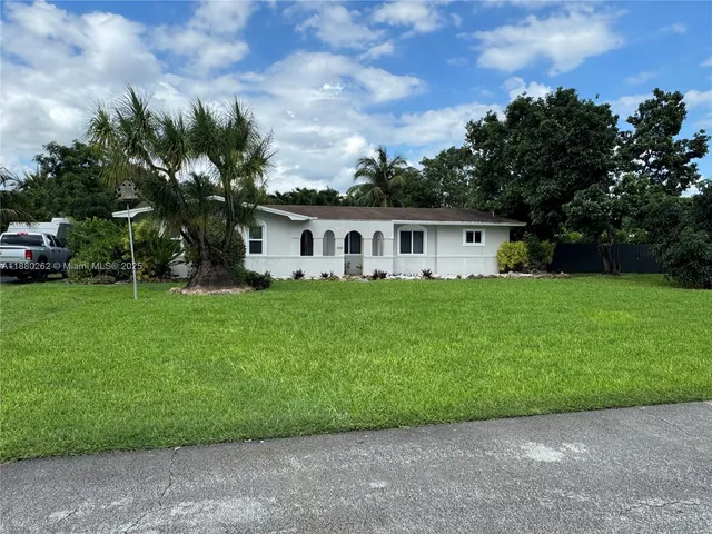 a view of a house with a yard and sitting area