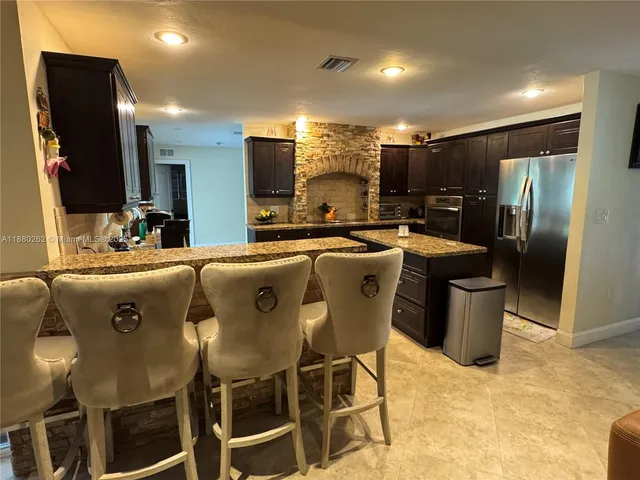 a kitchen with stainless steel appliances kitchen island granite countertop a sink and cabinets