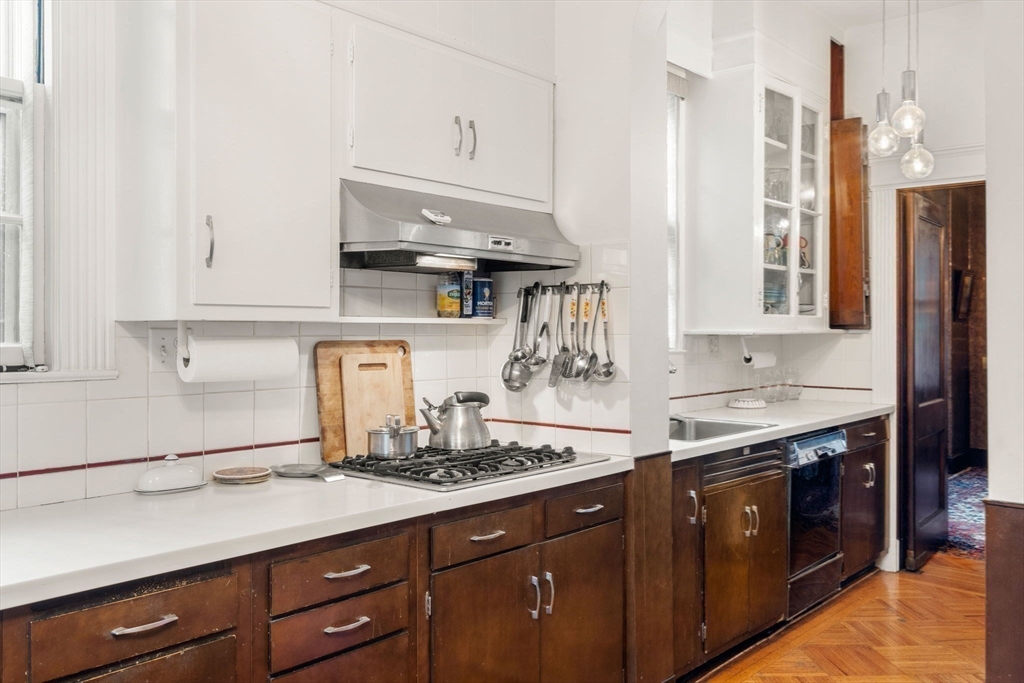 17 Berkeley Street Cambridge, MA 02138 - Photo 10 of 37 a kitchen with stainless steel appliances granite countertop a sink a stove and wooden cabinets