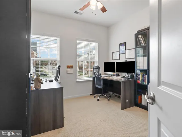 a view of a workspace with furniture and a window