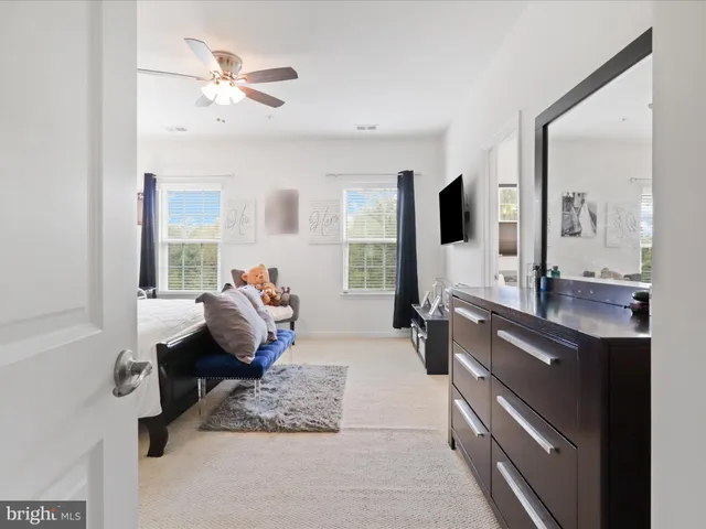 a bedroom with a bed flat screen tv and window