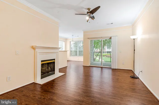 a view of a livingroom with wooden floor a fireplace and windows