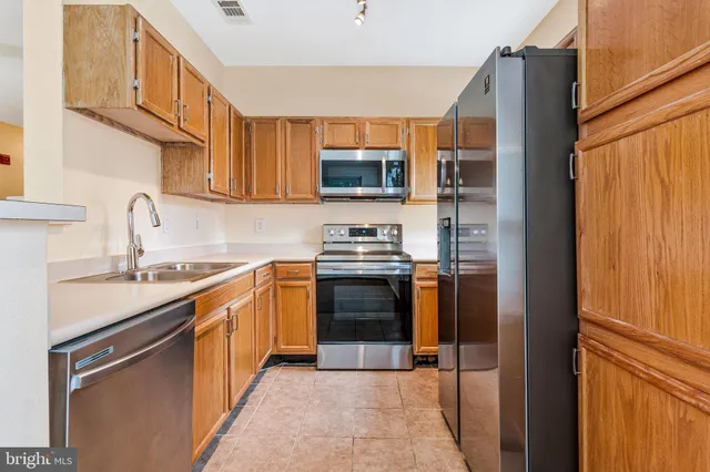 a kitchen with stainless steel appliances a stove sink and microwave