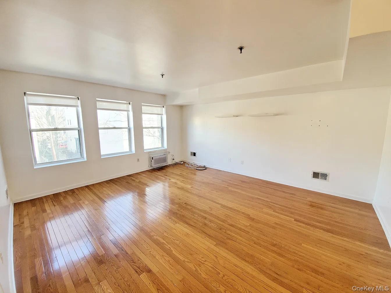 115 Vanderbilt Avenue, Unit 115A Brooklyn, NY 11205 - Photo 8 of 10 wooden floor in an empty room with a window
