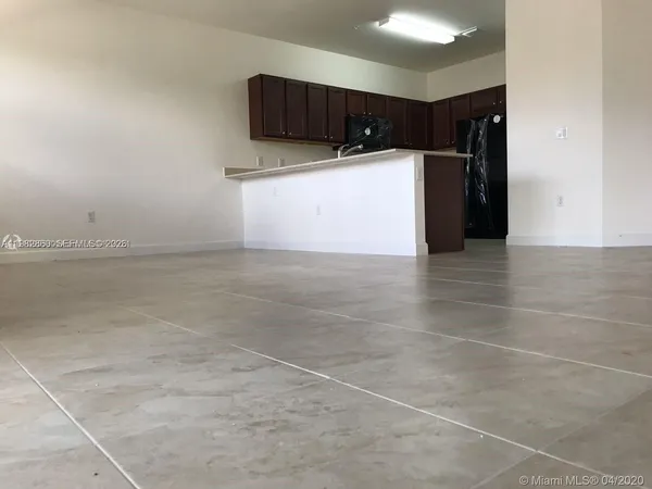 a view of kitchen with refrigerator and cabinets