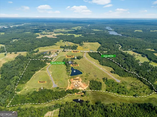an aerial view of residential houses with outdoor space and trees